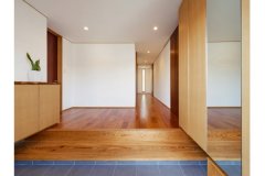 地松の一枚板が高級感を漂わせる玄関框。廊下突き当たりを左に行くと、水廻りからキッチンへと抜ける