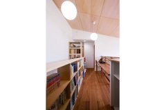 2階には造作の本棚、カウンターが廊下に並ぶ。本棚と同じ素材を使った天井も自然な明るさで2階に閉塞感を感じさせない