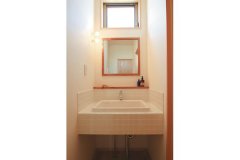シンプルな木枠の鏡と白いタイルが印象的な、造作の洗面台