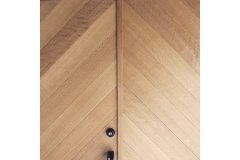 玄関扉。素材はオーク（ナラ）を使用。LDKの床材や窓枠などと同じ材質のもの。デザインはお任せいただき両開きならではのものとなった。カフェの入口のような雰囲気でオシャレな空間を想像させる玄関扉となった