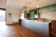 ステンレスの光沢が美しいアイランドキッチンは広々サイズ。壁面に施したスイス漆喰がこもりがちな調理の匂いや湿気を吸収。