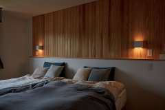 無垢板張りの壁に間接照明をあしらった、北欧風の心安らぐベッドルーム。