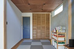 市松敷きの琉球畳に板畳を合わせてLDKとの一体感を高めた和室。モルタル調の壁1面はご主人自ら塗装したもの。