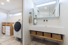 洗面台と脱衣室に仕切りを設けて使いやすい空間に。脱衣室と洗濯場を同じスペースにすることで、家事効率もアップ。
