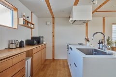 真っ白なキッチンとレンジフードは「無印良品」オリジナル。背面はキャビネットの高さに合わせて天板を造作。