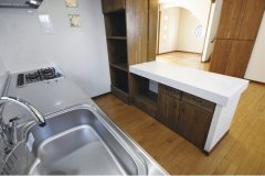 奥さまこだわりの、真っ白なタイルのキッチンカウンター。横にはオリジナル造作棚