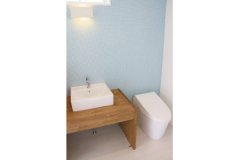 ブルーの小さなタイルの壁が爽やかな印象の清潔感のあるトイレ