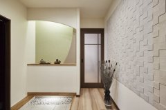 家じゅうを回遊できる動線へとつながる玄関。玉砂利と間接照明が上質感を生む。壁のエコカラットでデザイン性と調湿・消臭機能も向上。