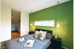 緑のアクセントウォールが印象的な寝室