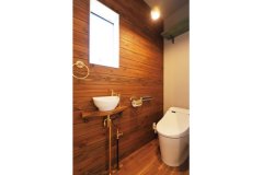 木材のアクセントウォールが雰囲気のあるトイレ
