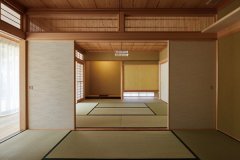 本格的な二間続きの和室。床の間と吊り押し入れ、格子の間境欄間など、伝統建築の様式美を表現。