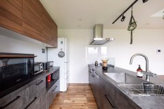 「グラフテクト」のキッチンは扉付きの収納でいつもすっきり。テーブルやウォールパネルも同じ素材でコーディネートし、統一感のある空間に。