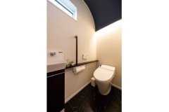 ご主人の感性でデザインしたトイレ。柔らかな曲線を描く濃紺色の天井から、間接照明の明かりがこぼれます。