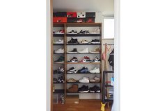 玄関奥の収納スペースに専用の棚を設け、Oさんご夫婦が長年収集したスニーカーを整然と並べています。