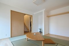 シンプルに設えた広い和室。隣接する玄関にはヒノキ造りのストリップ階段を設置。