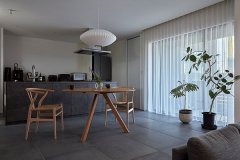 差し込む陽光と抜け感が心地よいLDK。曲線的なデザイナーズ家具や照明が映える。