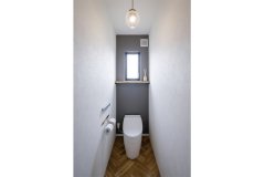1階トイレは真ちゅうのペーパーホルダーでシンプルに。寝室や子ども部屋も1面だけクロスの色を変えています。